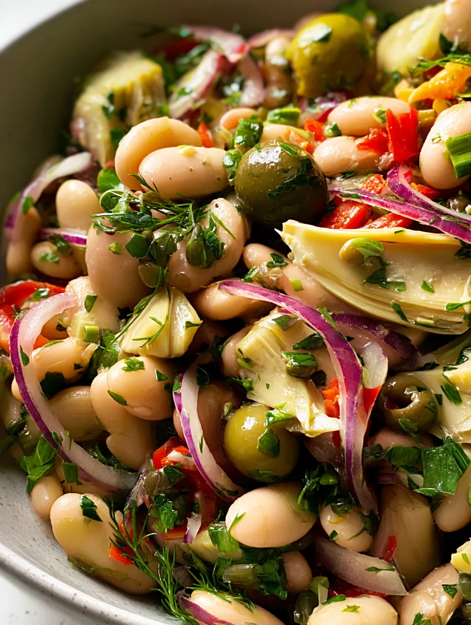 A bowl of vegetables with olives, beans, and peppers.