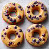 Blueberry donuts on a plate with berries.